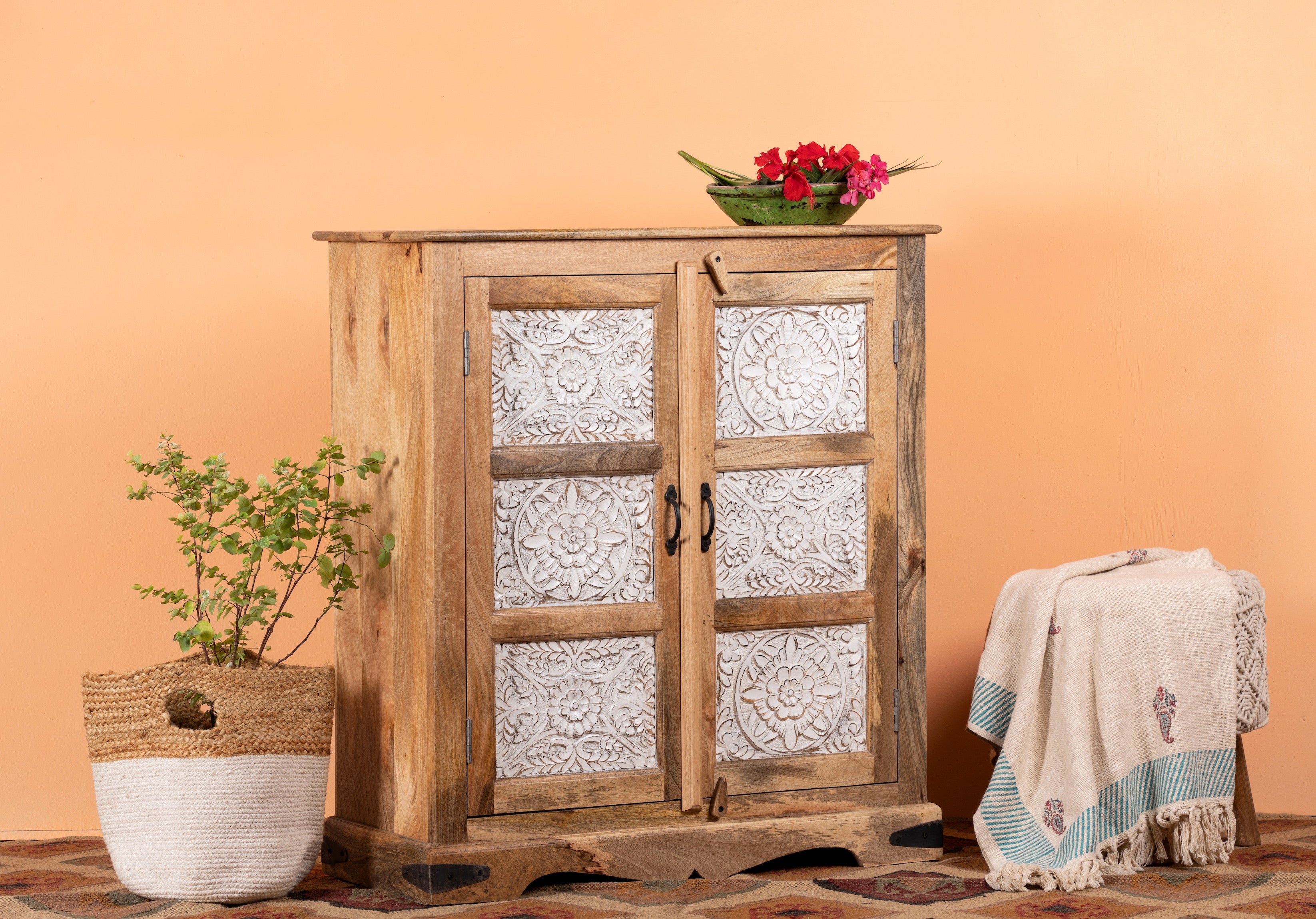 Side angle image of a carved sideboard / bedroom furniture in mango wood with white-washed floral engravings, 90 × 40 × 100 cm.