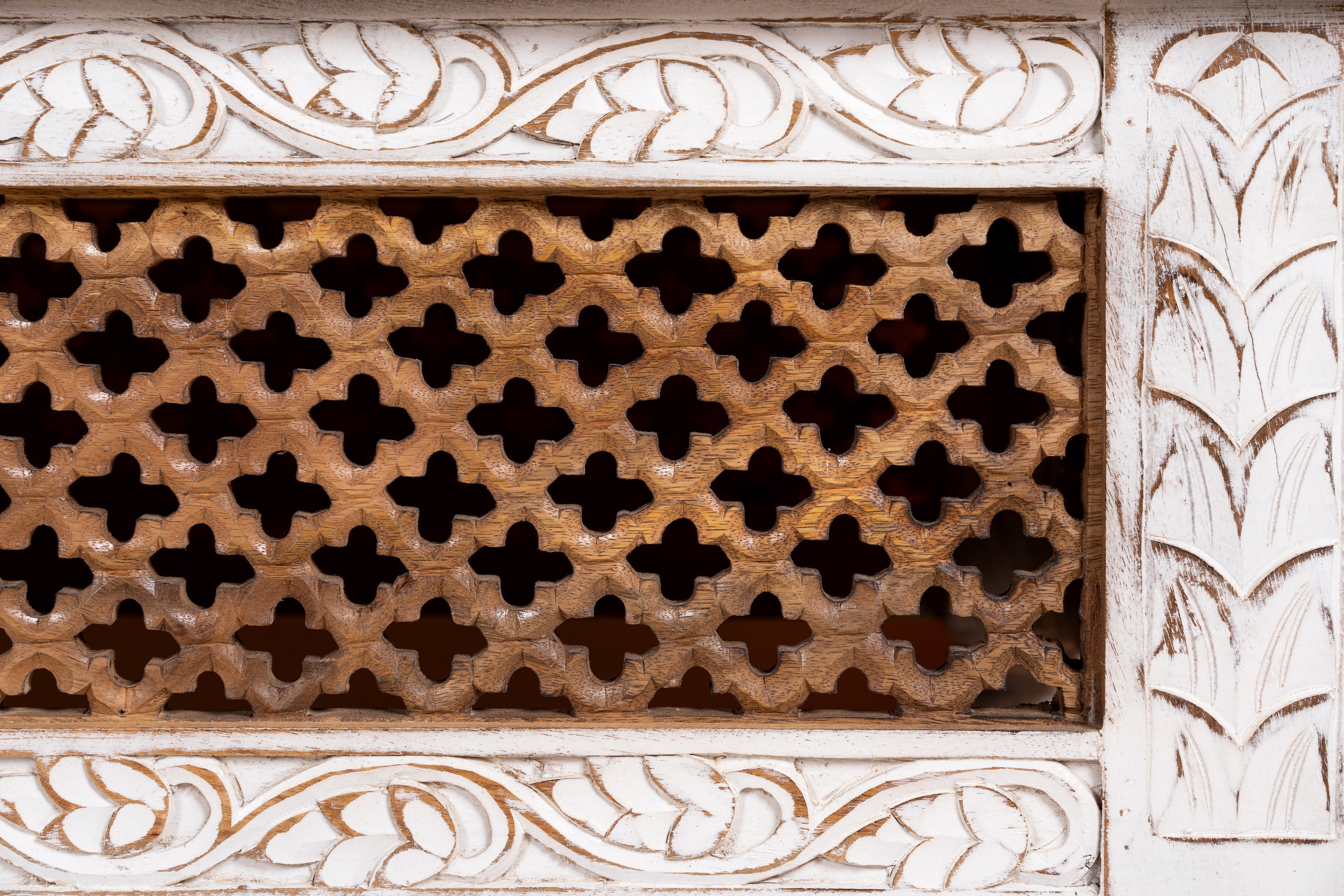 Close up image of a Hand carved mango wood coffee table with floral frame detailing; rustic natural finish, 140 × 90 × 46 cm.