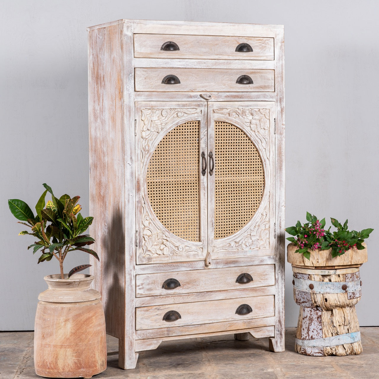 Side angle image of a handcrafted mango wood cabinet with rattan doors and carvings, living room furniture in whitewashed finish, 80 × 148 × 40 cm.