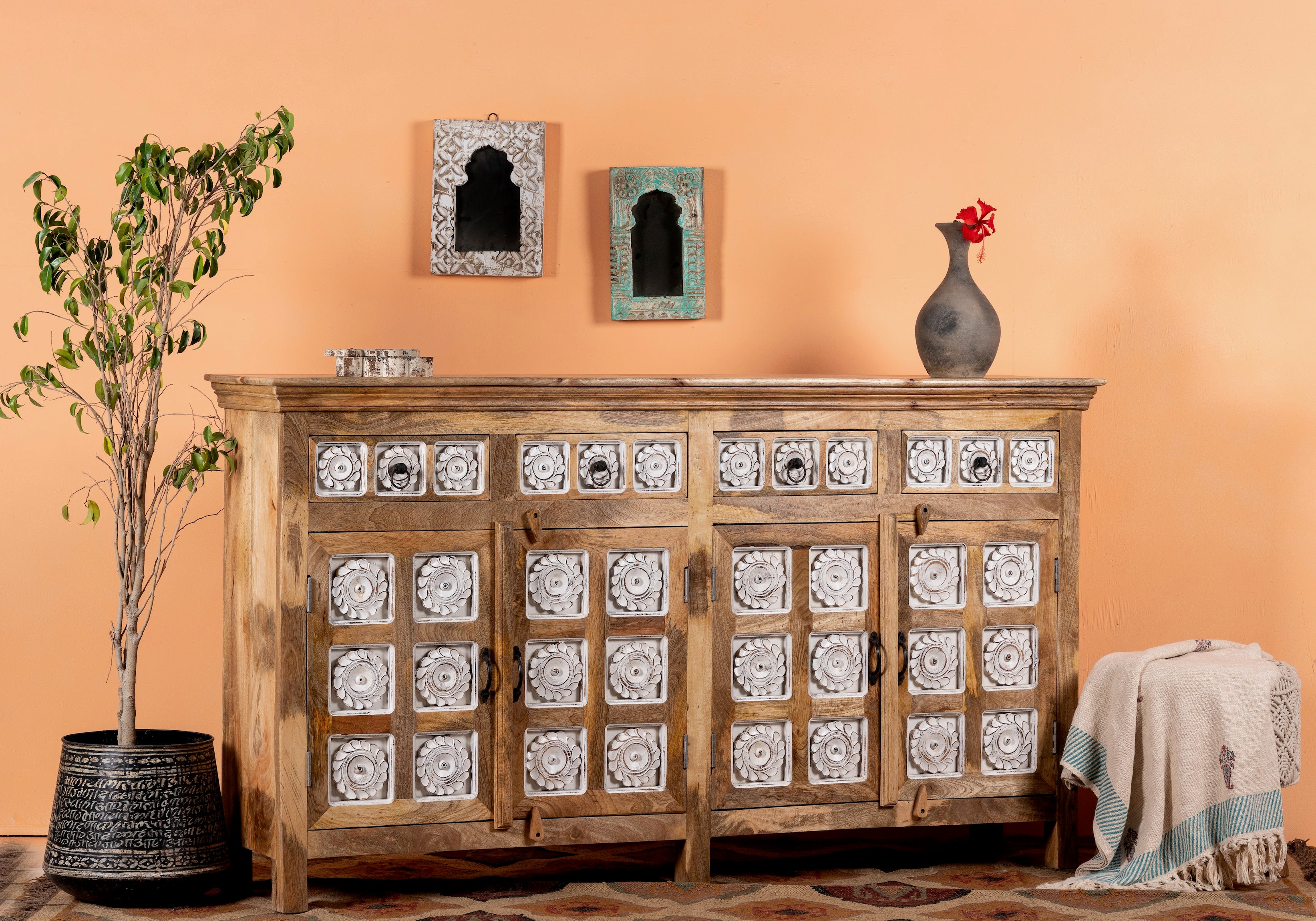 Side angle image of a hand-carved mango wood sideboard with whitewashed floral details; perfect as living room furniture or mango wood furniture for vintage interiors, 180 × 100 × 40 cm.