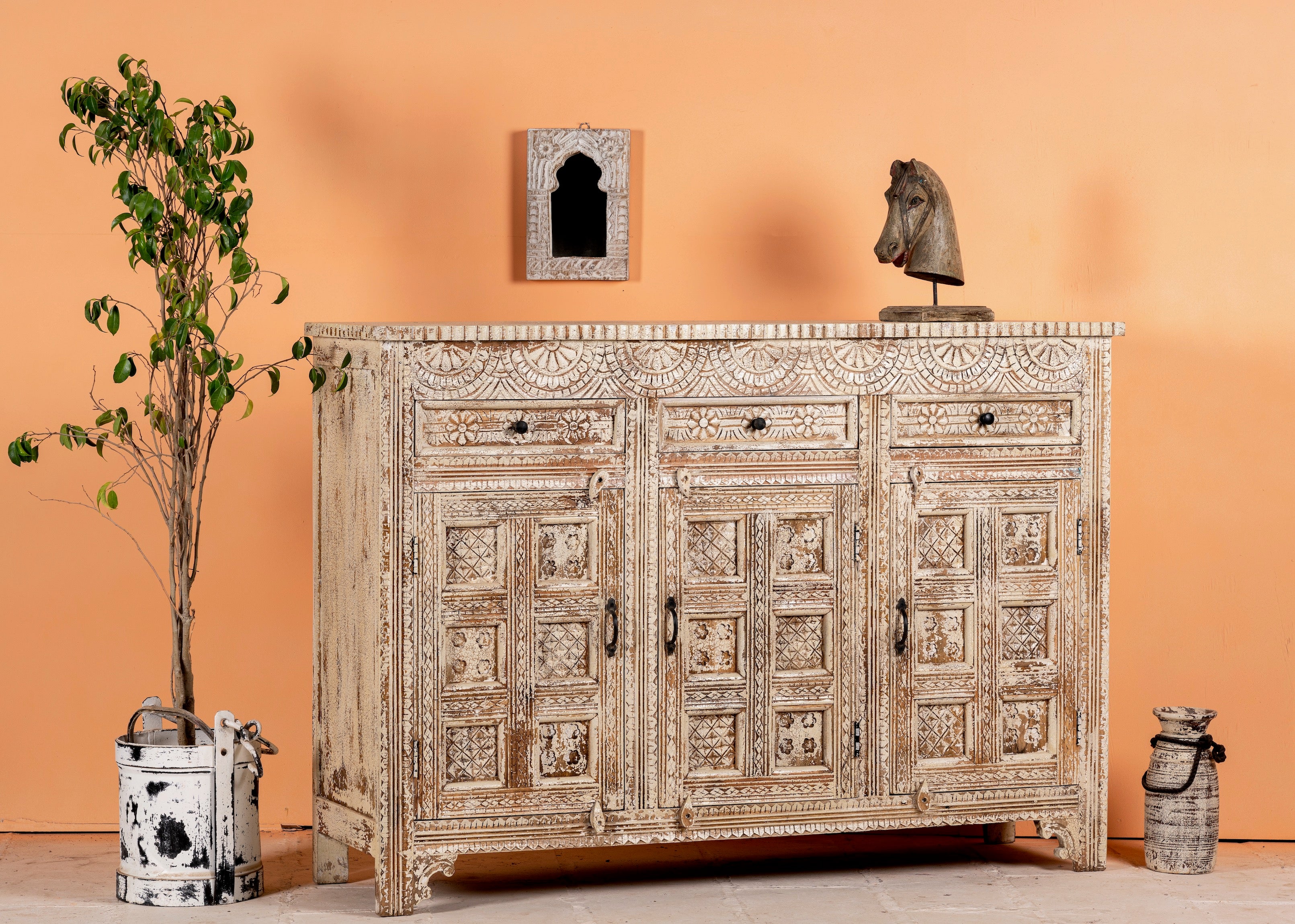 Side angle image of a hand-carved mango wood cabinet with three drawers and vintage distressed finish; ideal for mango wood furniture lovers and vintage home decor, 150 × 110 × 40 cm.