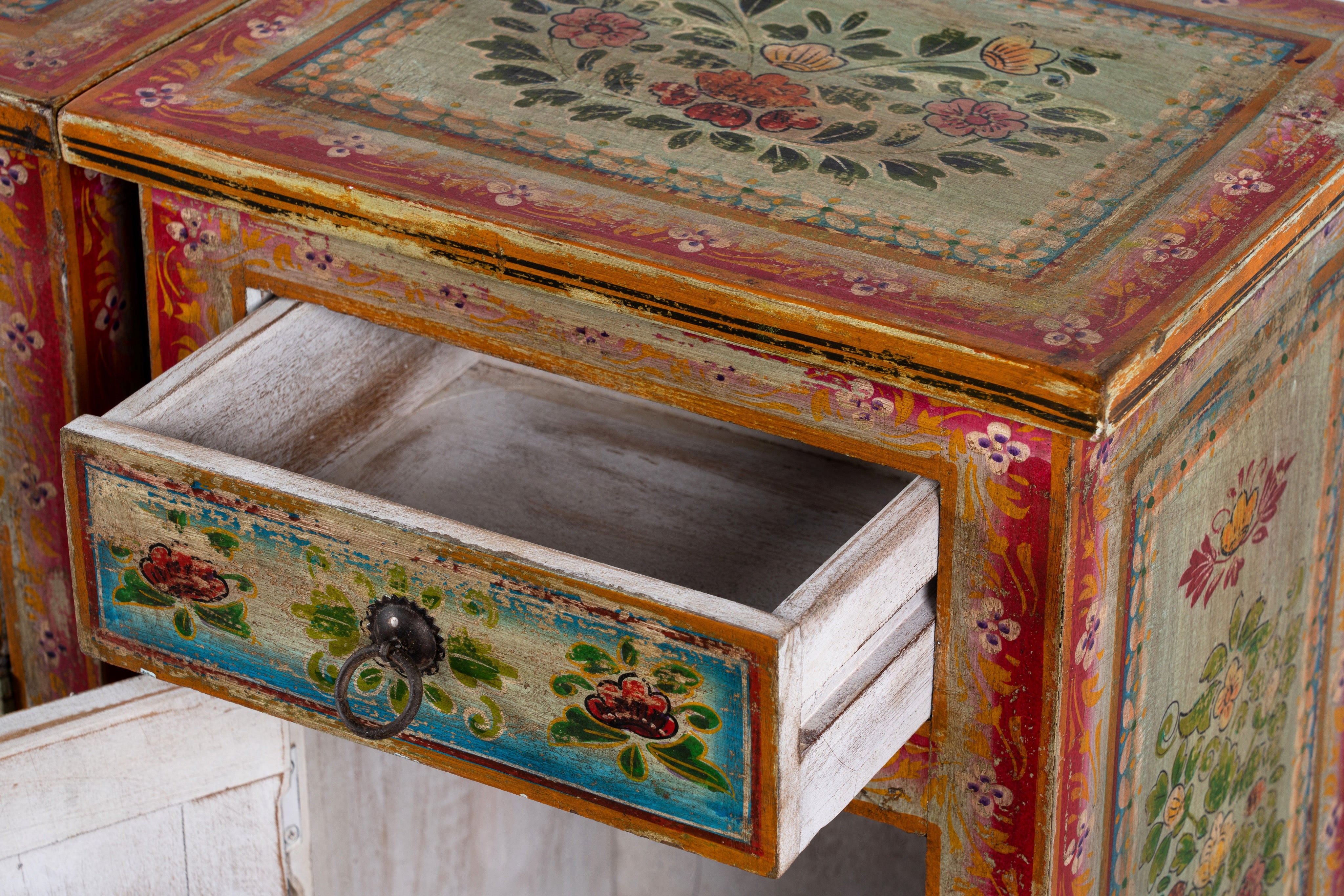 Open drawer image of a set of two hand painted bedside tables with floral motifs; sustainable furniture made of recycled wood, 45 × 35 × 70 cm.