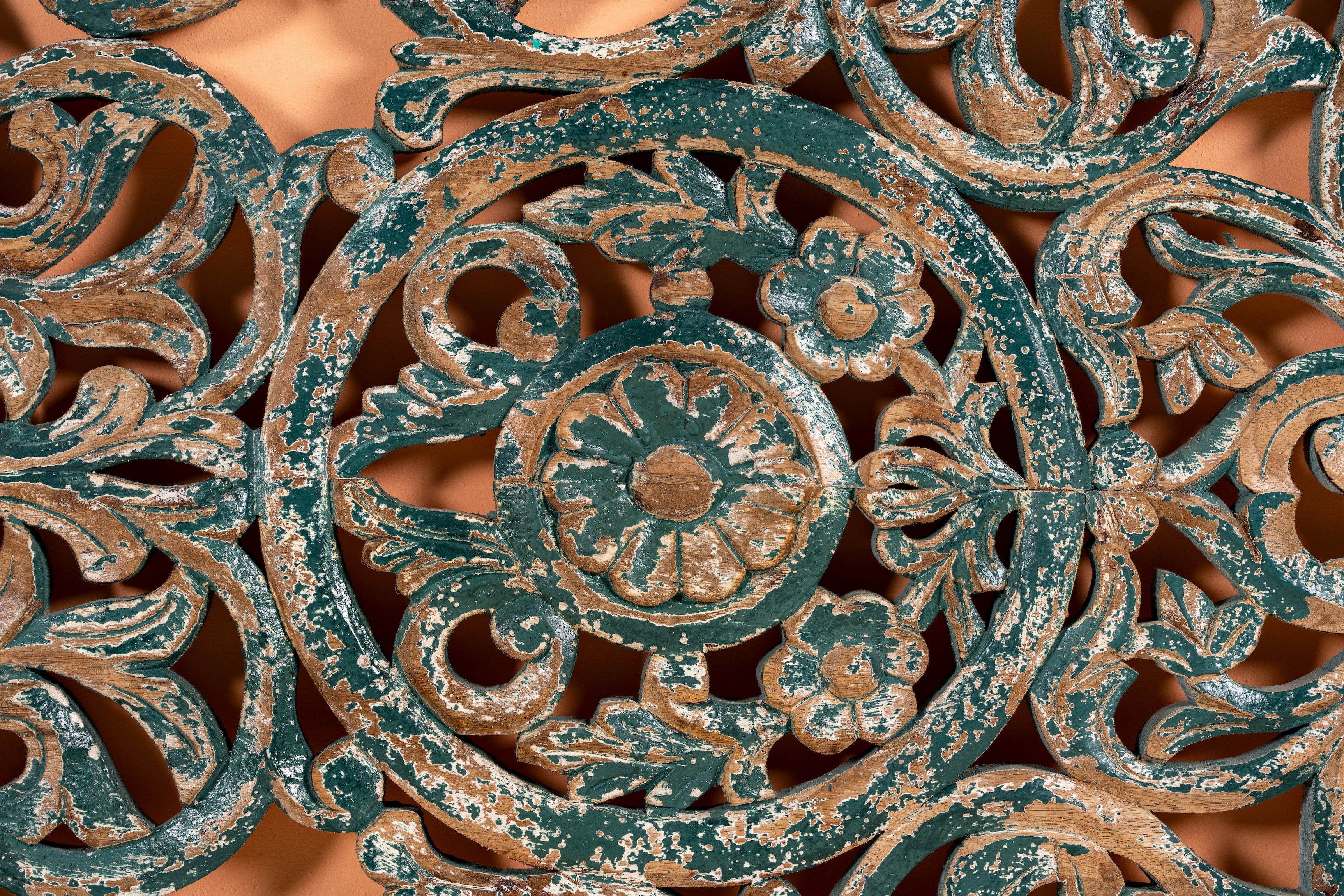 Close up image of a Nadya carved wooden wall panel made from mango wood with intricate floral carving—an elegant wooden wall decoration with natural texture and artisan detail.