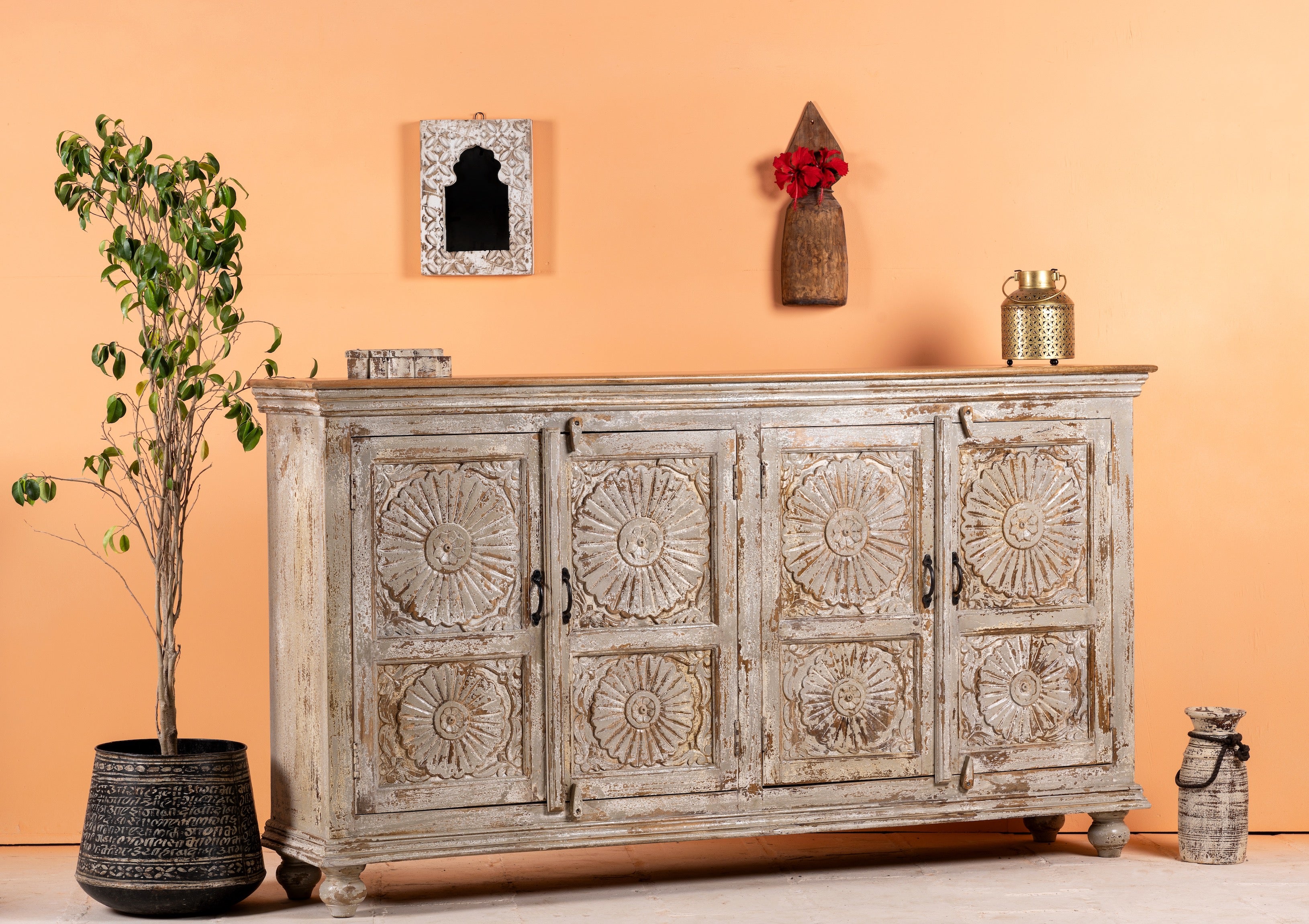 Side angle image of a handcrafted carved sideboard made from reclaimed wood with floral motifs and distressed finish; suitable as bedroom furniture, 180 × 40 × 100 cm.