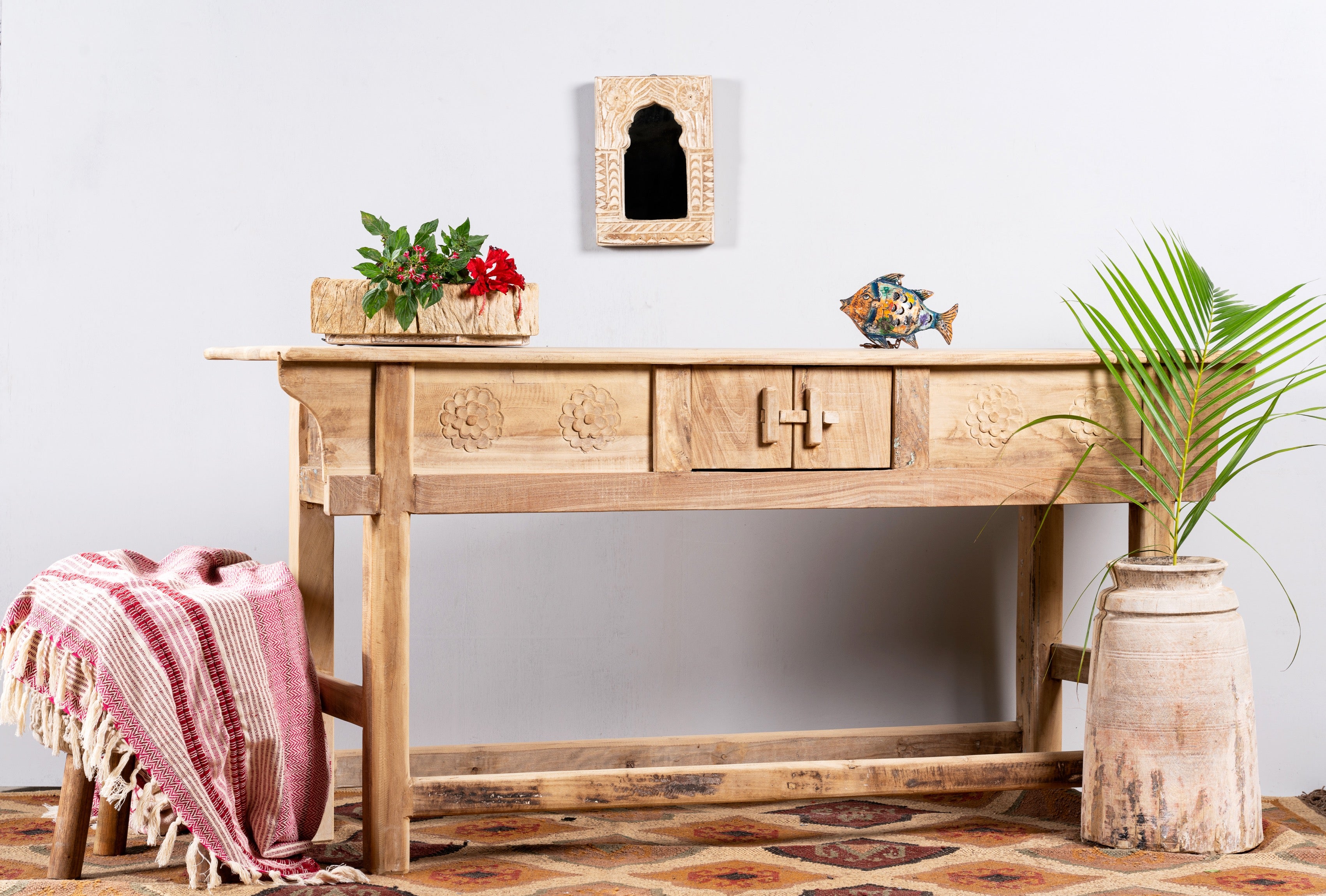 Side angle image of a rustic reclaimed teak console table with hand-carved detailing and hidden side compartments; sustainable furniture, 170 × 82 × 48 cm.