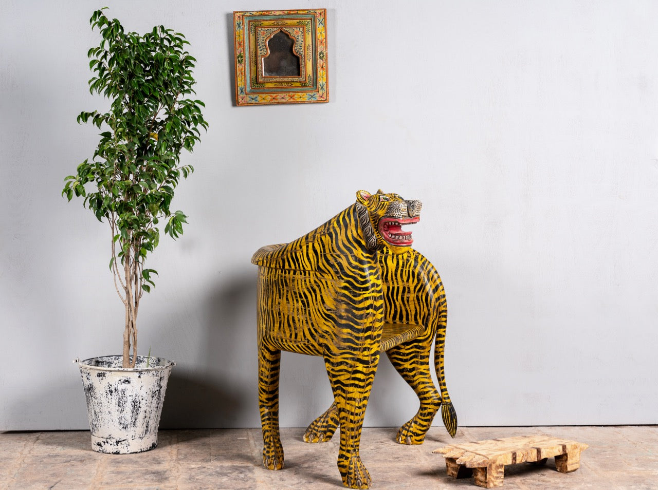 Side angle image of a hand-painted tiger chair made from recycled teak wood with carved tiger motif; ideal for a boho chic living room, 87 × 75 × 96 cm.
