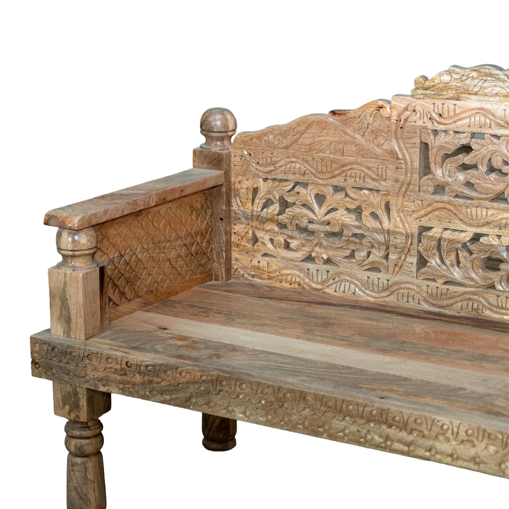 Close up image of a hand carved mango wood bench, featuring intricate floral detailing and turned legs, representing traditional Indian craftsmanship and authentic hand carved wooden furniture design.