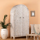 Side angle image of a white-washed hand-carved mango wood cabinet in Ibiza style, a statement piece for vintage home decor.