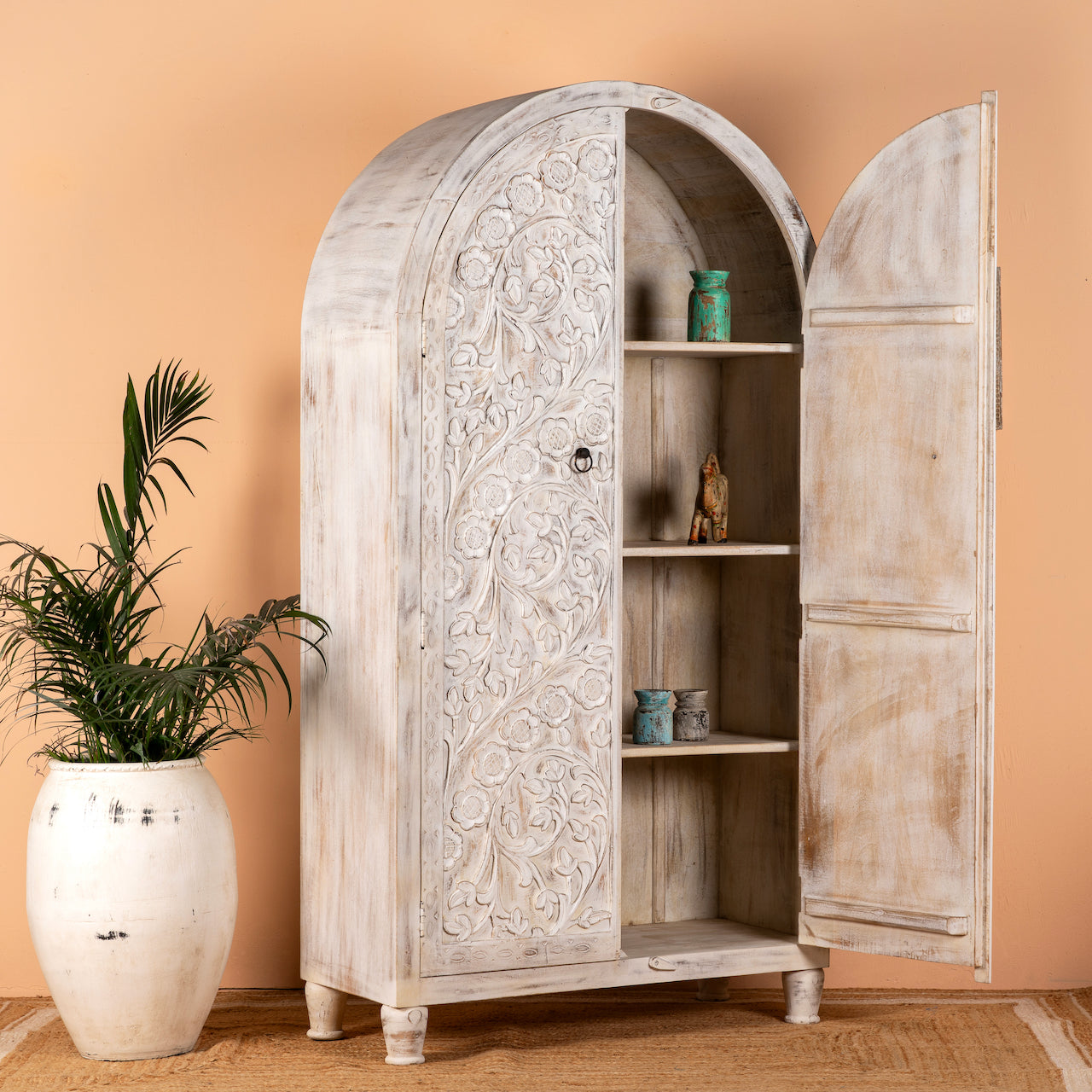 Open door image of a white-washed hand-carved mango wood cabinet in Ibiza style, a statement piece for vintage home decor.