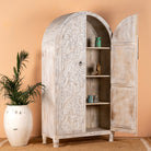 Open door image of a white-washed hand-carved mango wood cabinet in Ibiza style, a statement piece for vintage home decor.