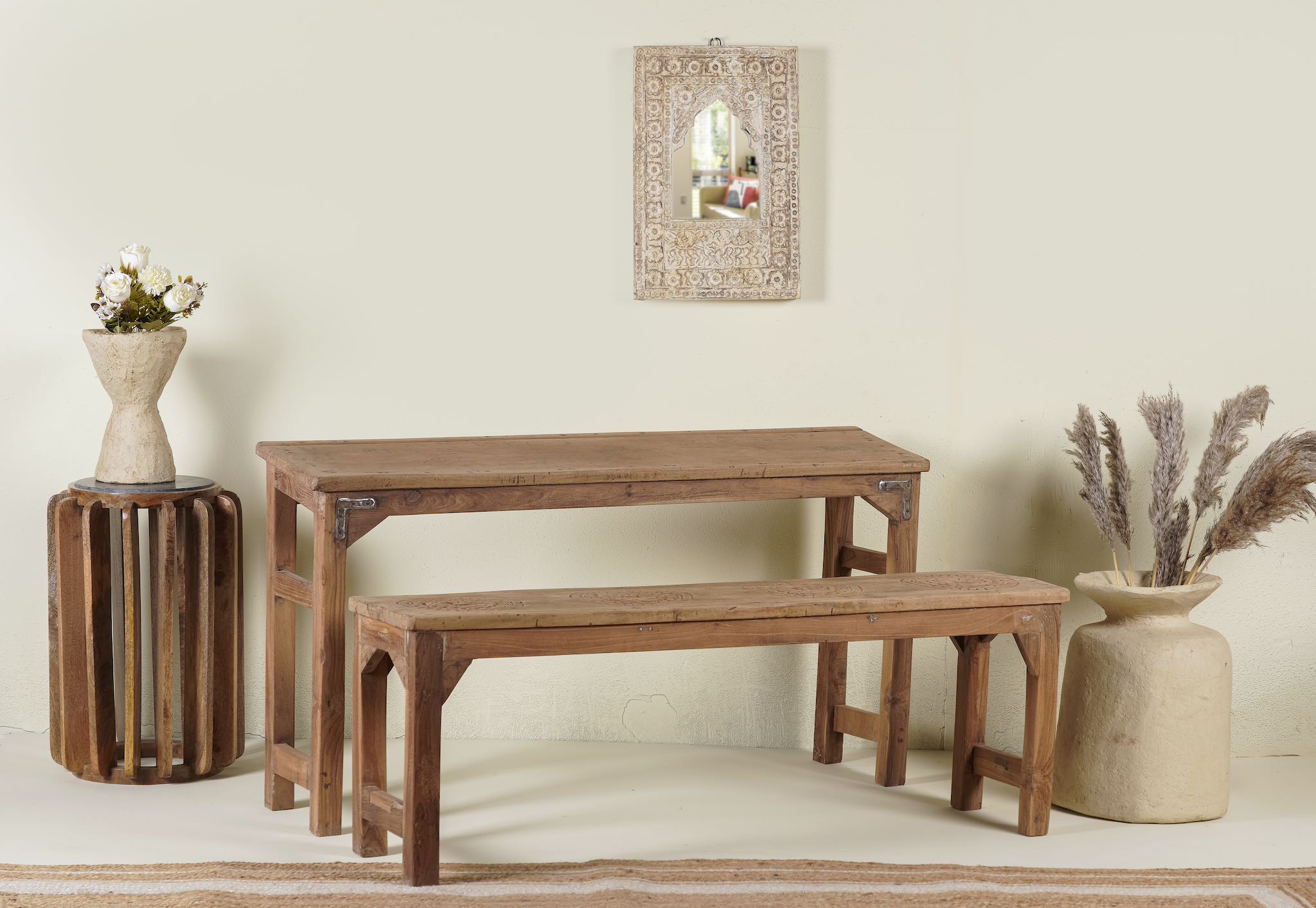 Side angle image of the vintage school bench set Adil from India, crafted from old teak wood, featuring a simple, sturdy design with a long bench and matching table in a natural, weathered finish, styled in a neutral-toned interior with rustic decor accents.
