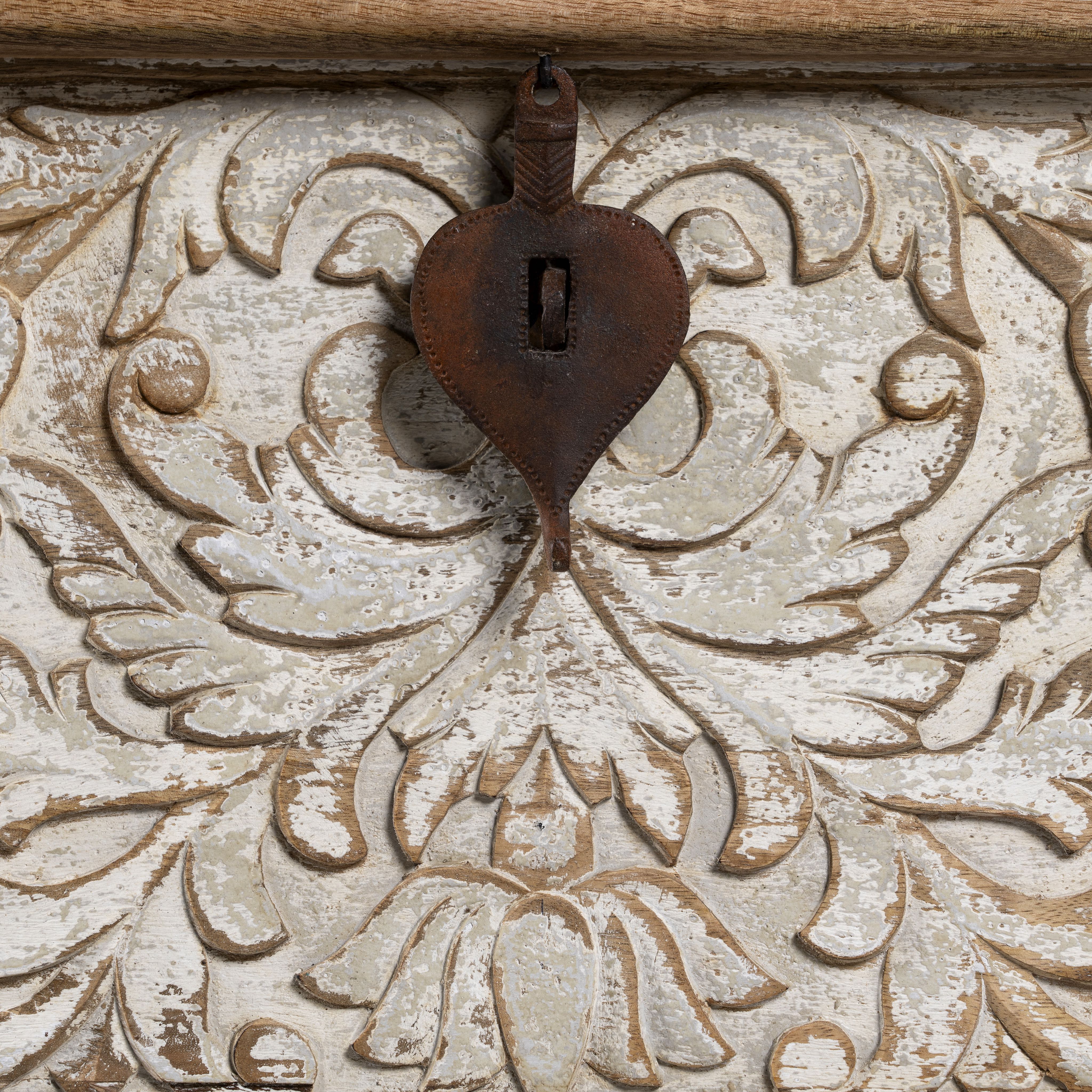 Close up image of a hand-carved mango wood chest box with floral whitewashed detailing and iron handles – vintage home accessory and unique furniture with rustic charm.