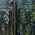 Close up image of a hand painted cupboard made from recycled wood with floral motifs, two drawers and two doors, 90 × 90 × 40 cm.