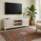 Lifestyle imagination of a white washed mango wood lowboard with carved floral doors and open shelving, 180 × 40 × 60 cm.