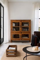 Lifestyle image of a reclaimed teak wood display cabinet with four glass-panelled doors – wooden showcase cabinet crafted as sustainable furniture with timeless appeal.