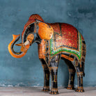 Large hand-painted decorative elephant sculpture made of sheet metal in vibrant Rajasthani style, featuring intricate floral and geometric patterns in red, green, and gold. Ideal for enhancing entrance areas, restaurant lobbies, hotel receptions, or luxury interior spaces.