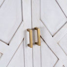 Close up image of a tall whitewashed mango wood cabinet with carved lines and antique brass iron base, 91 × 154 × 43 cm.