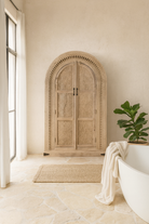 Hand-carved wooden wardrobe with arched silhouette and floral detailing – Ashwin by Om Home & Garden, artisanal mango wood furniture with vintage character.