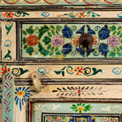 Close up image of a hand painted cabinet made from reclaimed wood with colourful traditional Indian motifs, 90 × 90 × 40 cm.