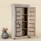 Open door image of a handcrafted wooden wardrobe made from antique Indian teak doors with iron accents and floral carvings, combined with a solid mango wood body. A tall, rustic cabinet ideal for vintage-inspired or heritage-style interiors.