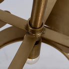 Close up image of a medium round brass-plated metal pendant lamp with geometric cutout design – a modern take on vintage lights perfect for dining rooms, kitchens, or stylish living areas.