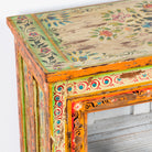 Close up image of a hand-painted teak wood display cabinet with glass doors and vibrant Indian motifs – sustainable furniture with vintage charm and artisanal detail.
