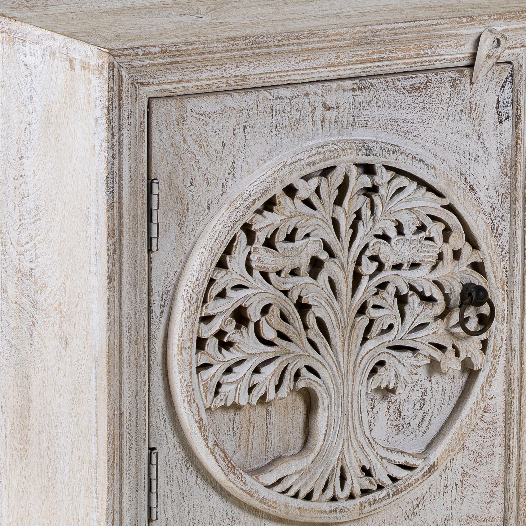 Close up picture of a pair of nightstands made from mango wood, featuring hand-carved tree of life designs on the doors and a whitewashed antique finish for a serene, artisanal look.