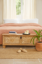 Lifestyle image of a hand-carved mango wood vintage chest with floral carvings – Mediterranean-style storage chest for living rooms, bedrooms, or bathrooms.