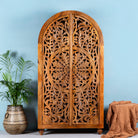 Half-round mango wood wardrobe with floral carvings, a unique example of sustainable furniture and artisanal furniture.