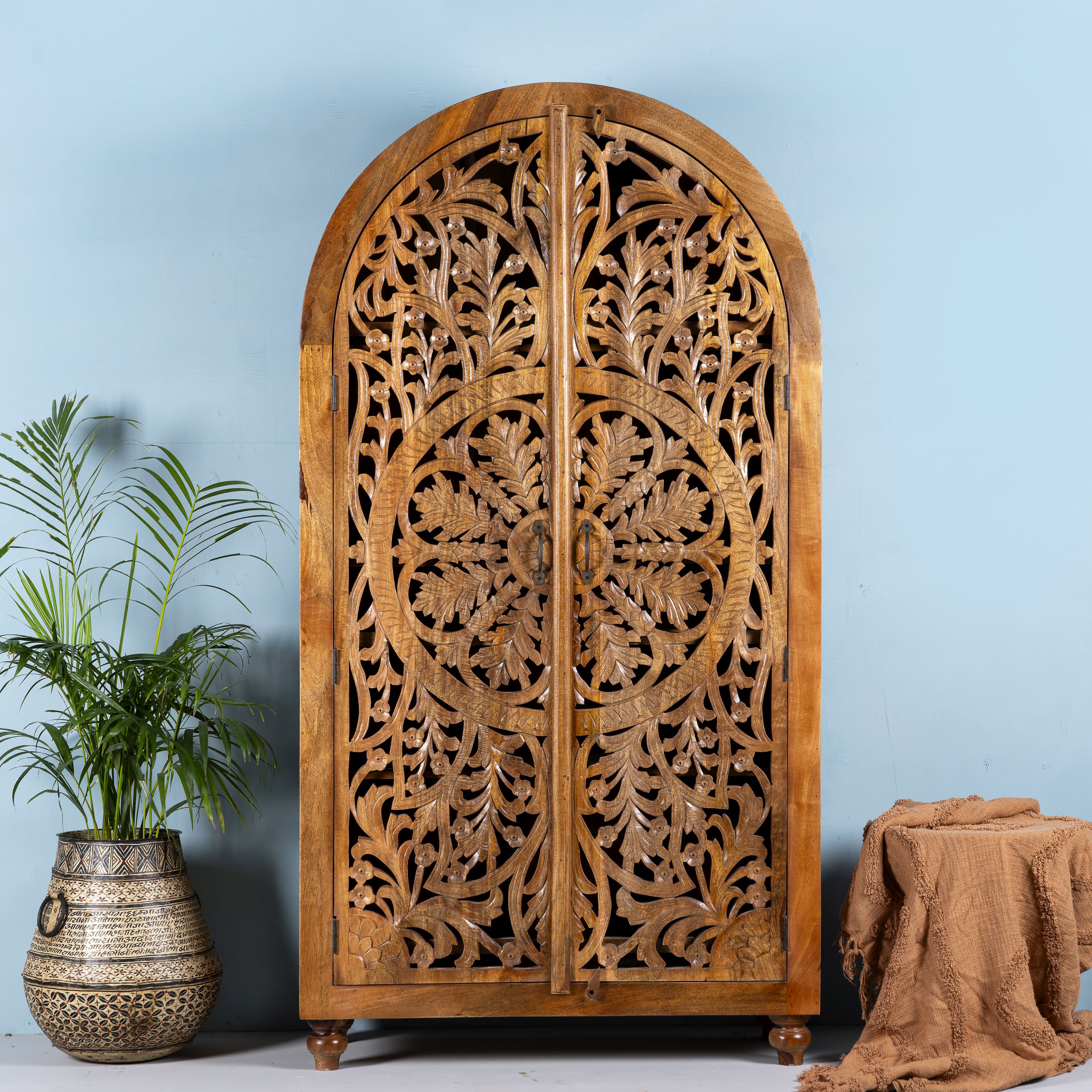 Half-round mango wood wardrobe with floral carvings, a unique example of sustainable furniture and artisanal furniture.