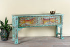 Side angle image of a hand-painted reclaimed wood console table Bunsee with tiger and leopard motifs in turquoise vintage finish. A unique piece of furniture for bohemian interiors and artistic spaces.