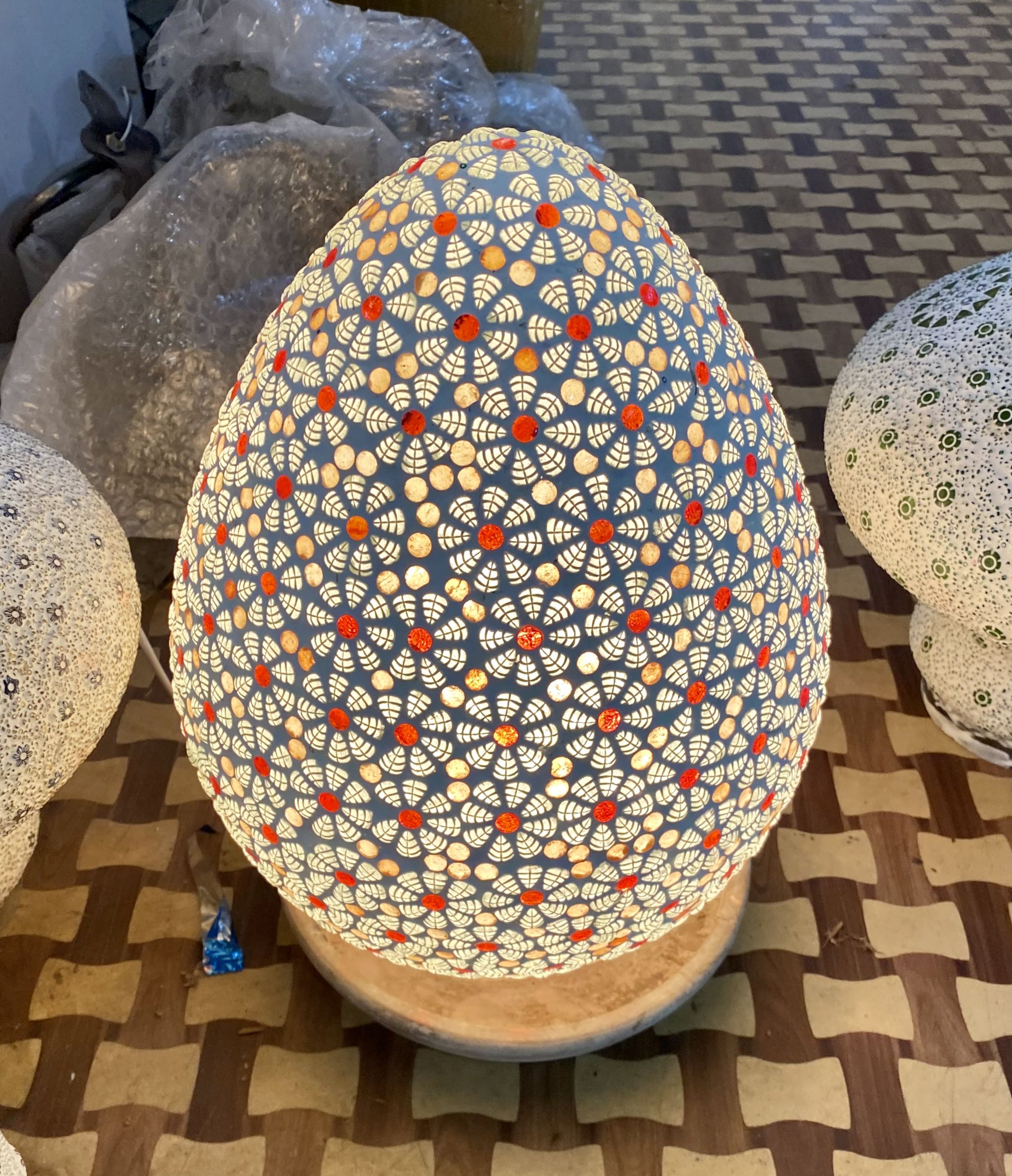 Lighted sample for a mosaic pendant lamp Bhuv with round ceiling panel and 7 hanging mosaic stone lights – handcrafted lighting design, 60 cm panel with 30x20 cm teardrop light bodies.