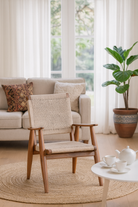 Lifestyle image of a Chameli acacia wood chair with hand-woven cotton rope seat and backrest—an artisan-crafted piece of wooden seating blending comfort and natural materials.