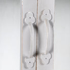 Close up image of a shabby chic teak wood cabinet with glass doors and five compartments – sustainable living room furniture crafted from refurbished old teak with rustic white finish.