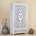 Side angle image of a hand-carved wooden wardrobe in white-wash finish, perfect for a boho chic living room or bedroom storage.
