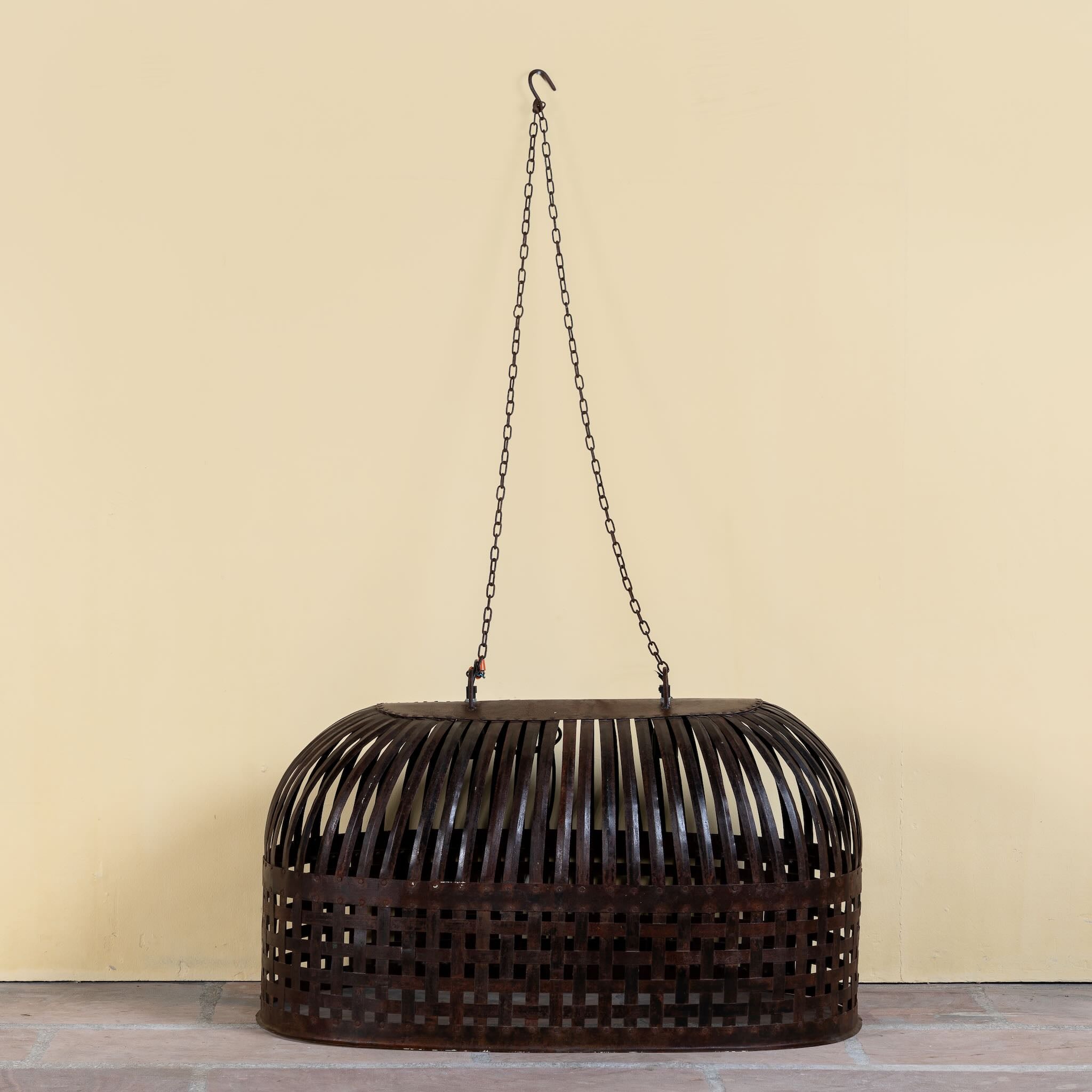 Chitra metal pendant light with hand-forged slatted design and iron chain suspension—an artisanal example of hand crafted metal lamps and bold metal pendant lights for high ceilings.