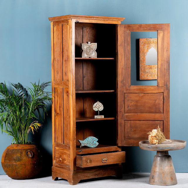 Side angle image with open door of a antique teak wood display cabinet with glass door, shelves, and lower drawer – unique furniture piece crafted from teak wood with traditional Indian design and honey wax finish.