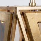 Close up image of a tapered pendant lamp with wood, brass cladding, and tinted glass panels – vintage lighting meets modern design, ideal for use as an iron pendant lamp in living rooms, dining areas, or entryways.
