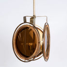 Side angle image of a artsy pendant lamp with 3-circle mango wood and brass-plated design, tinted glass inserts – vintage lighting piece for dining rooms, kitchens, or stylish living areas.