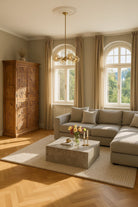 Living room scene of a hand crafted acacia wood cabinet with 4 doors, brass fitted door knobs and geometrical carvings.