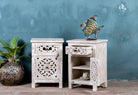 Side angle image with open doors of a Whitewashed nightstand made of mango wood with Mediterranean-style carved detailing and one drawer – Gagan bedside table by Om Home & Garden