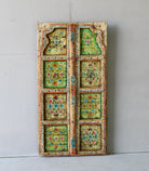 Gitra hand-painted teak door panel featuring floral motifs in soft pastels and a carved arched frame—an elegant and unique Indian wall decoration repurposed from antique architecture.