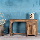 Front view of a desk made of reclaimed wood in Wabi Sabi style decorated in a living room scene.