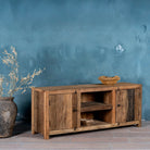 Side view image of a rustic sideboard in Driftwood/Wabi Sabi style made from recycled old wood, featuring a natural, weathered finish with two cabinet doors and open central shelving.



