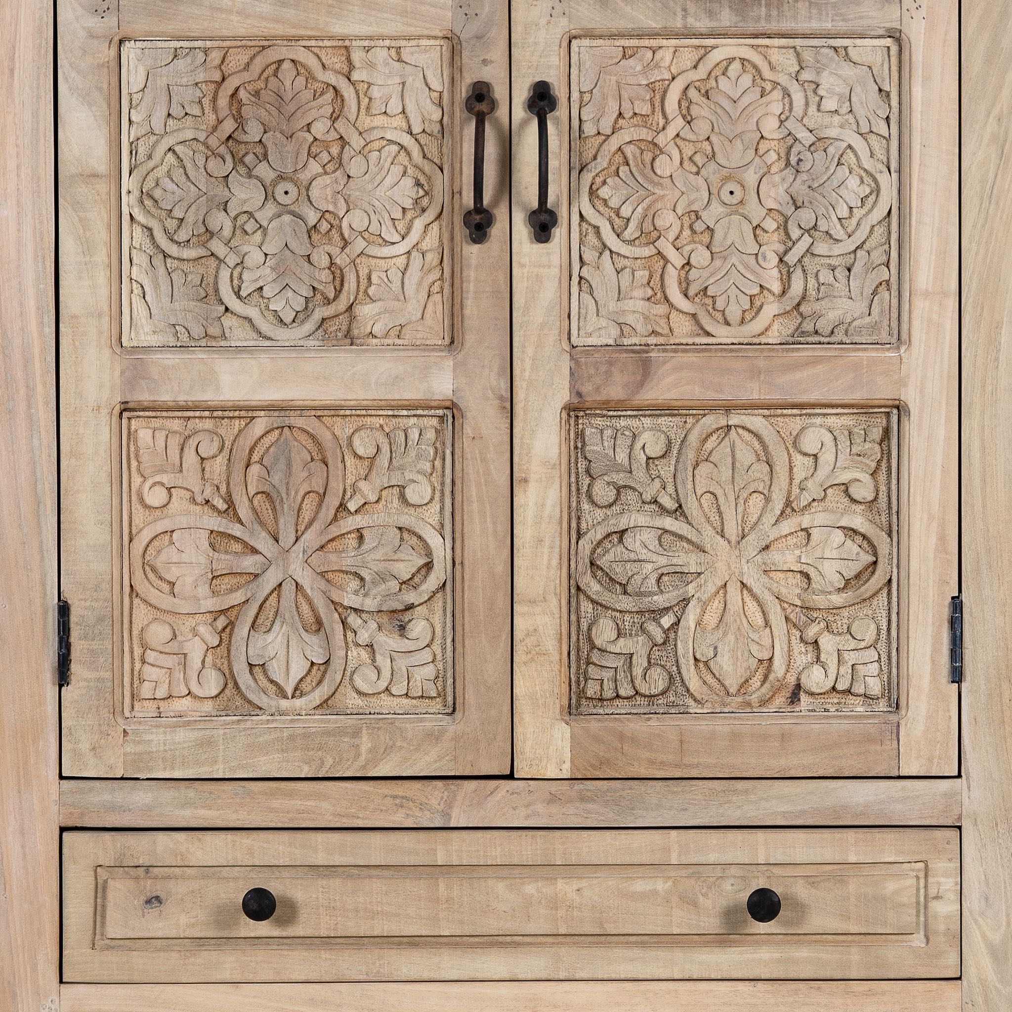 Close up picture of a hand carved mango wood cabinet with floral design, 2 doors and 2 drawers, in a living room scene.