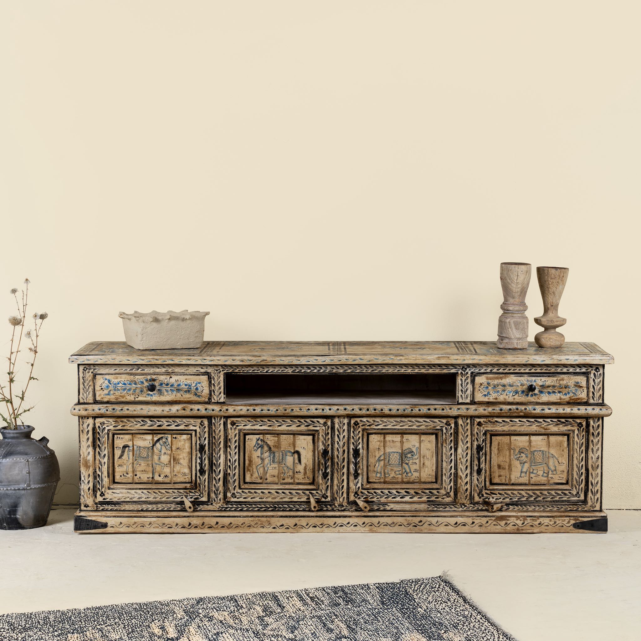 Front view image of a hand-painted lowboard made of reclaimed wood with traditional Indian animal motifs, featuring drawers and cabinets for storage, rustic finish, and artisanal detailing.

