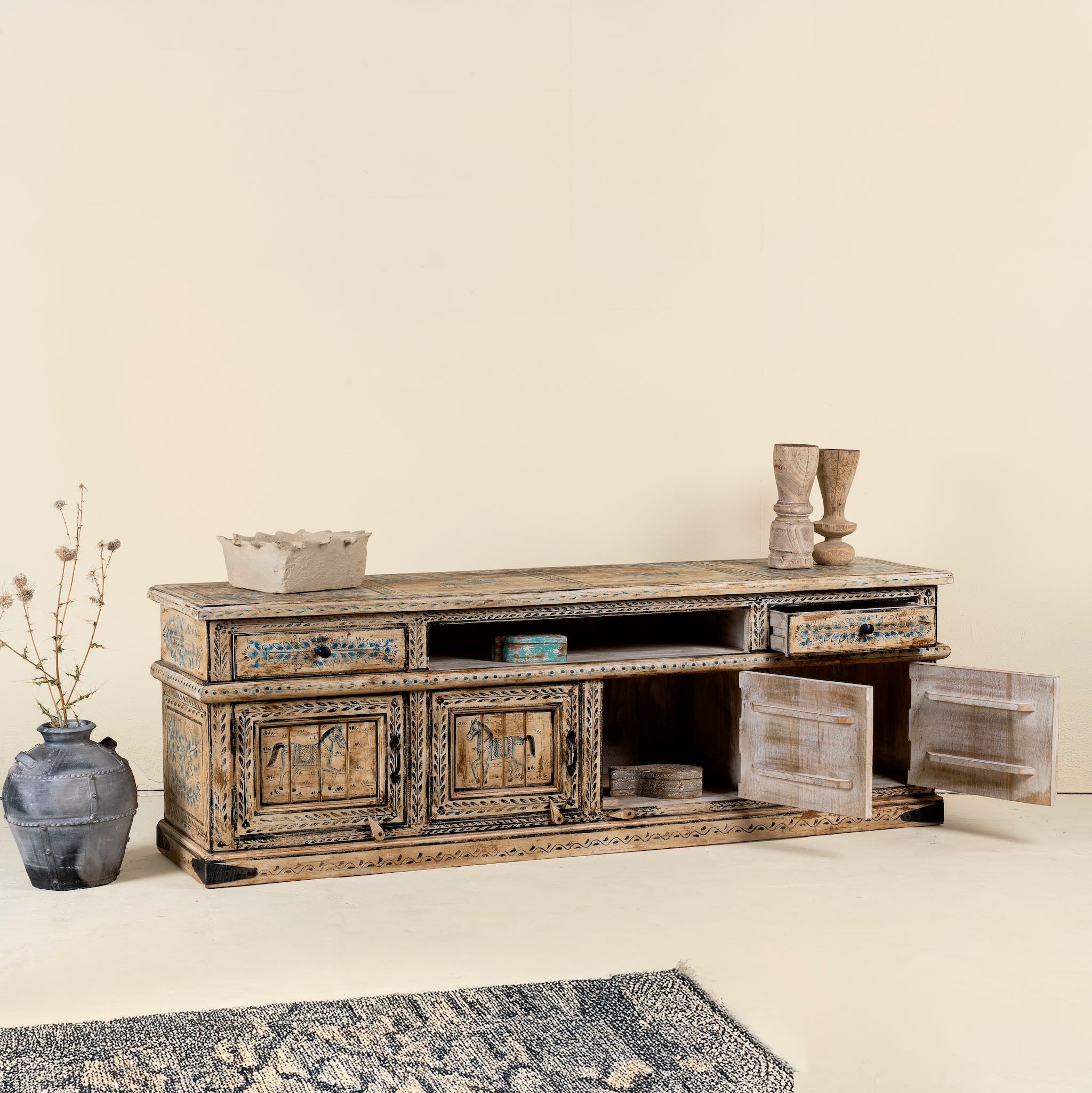 Side Angle image with open door  of a hand-painted lowboard made of reclaimed wood with traditional Indian animal motifs, featuring drawers and cabinets for storage, rustic finish, and artisanal detailing.

