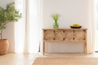 Lifestyle imagination of a reclaimed teak wood console table with hand-carved floral fronts and iron accents; sustainable furniture, 153 × 80 × 40 cm.