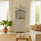 Lifestyle image of a Shivani mango wood house temple in whitewashed finish with carved floral doors and traditional arched canopy—an elegant example of hand-carved Mandirs and Indian home temples.