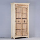 Side angle image of a rustic solid wood wardrobe featuring vintage reclaimed door panels with iron accents and ring pull handles.